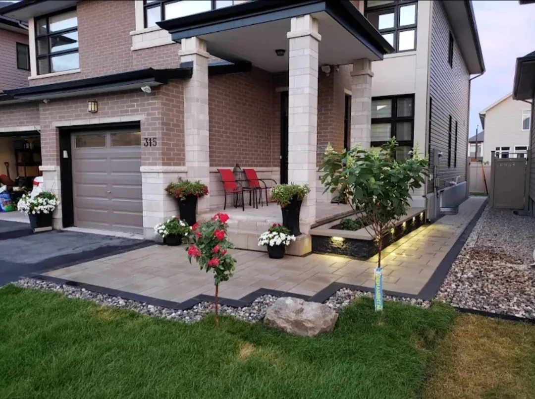 Front yard landscaping with lit paver walkway, gravel border and new sod