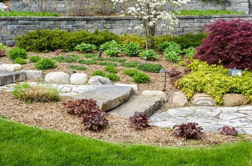 Multi-level garden with natural stone slabs, boulders and fresh plantings